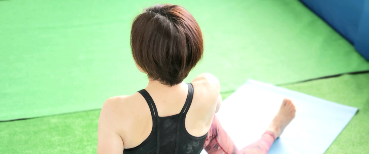 ヨガのポーズを取っている女性の後ろ姿